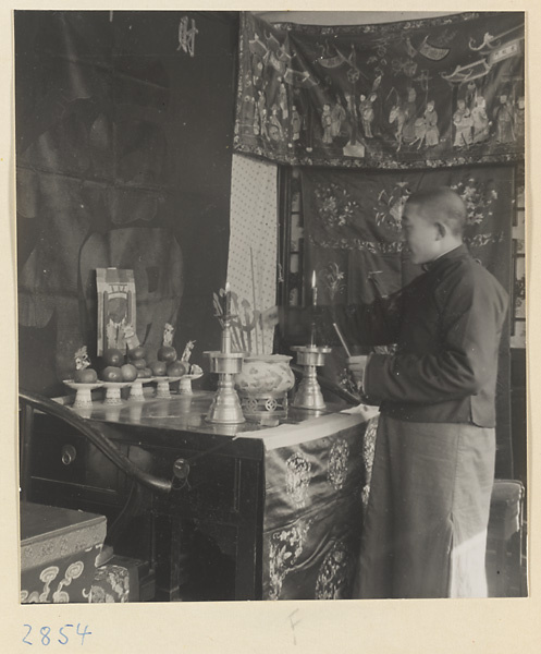 Man lighting incense at a New Year's altar