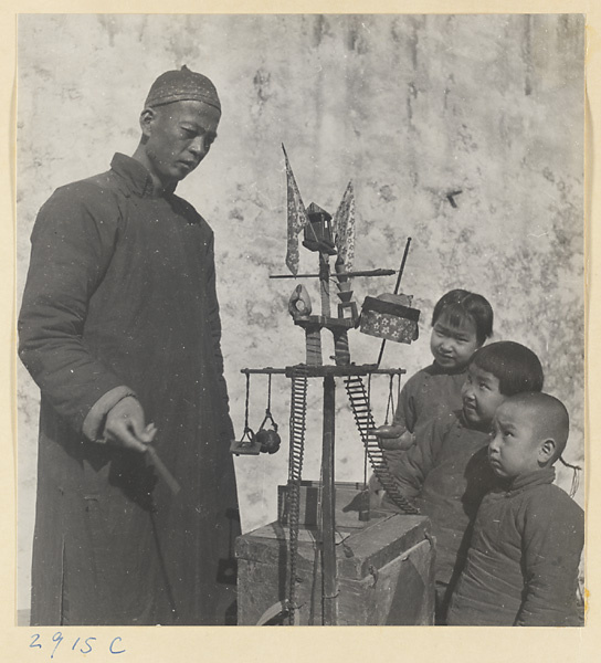 Street entertainer and children watching a performance of trained mice