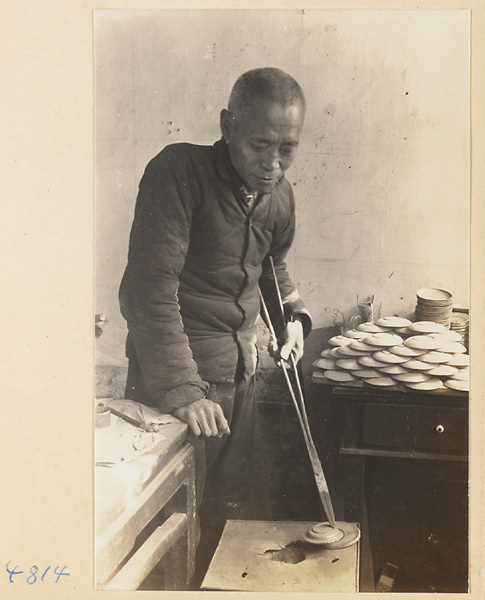 Man with long-handled shears working in a cloisonné shop