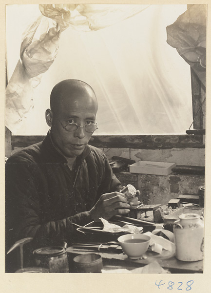 Silversmith at a workbench in a workshop