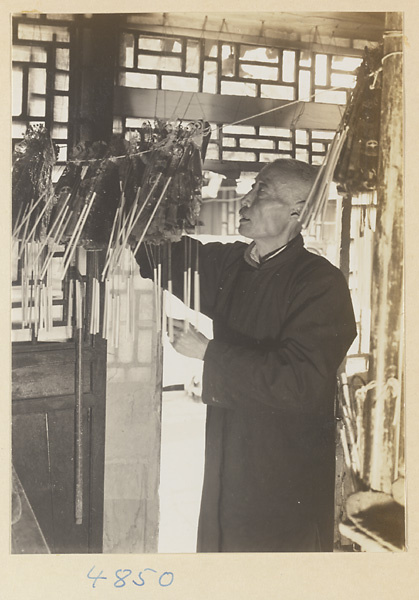 Puppeteer with a collection of shadow puppets hung on a string