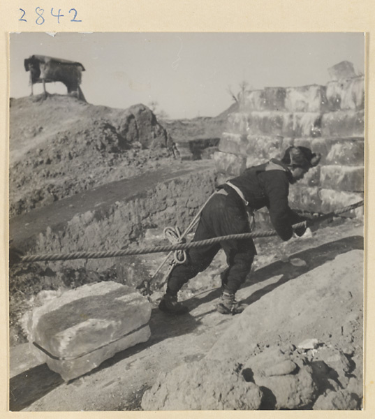 Person hauling a block of ice with a rope