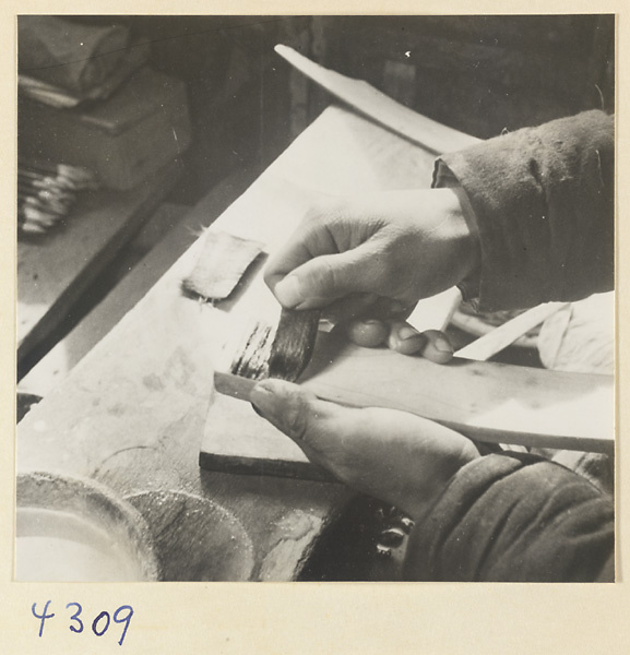 Man at work in a brush-making shop