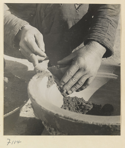 Man working on a cooking pot at a foundry near Mentougou Qu