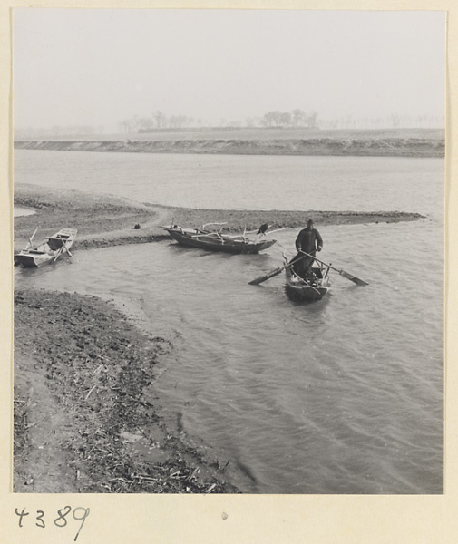 Fisherman, boats, and cormorant