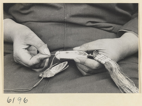 Woman working on an embroidered bag in the form of an insect