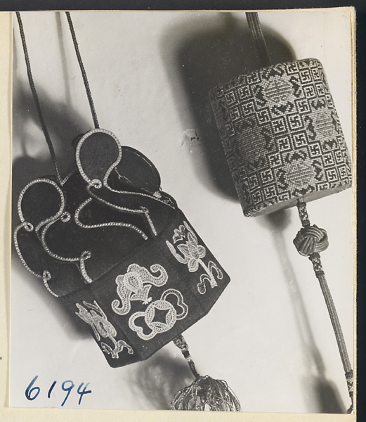 Two bags embroidered with characters, bats, swastikas, coins, and floral motifs