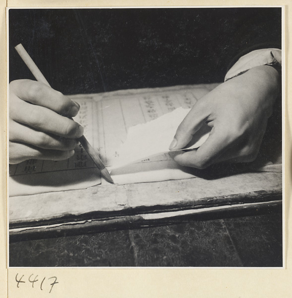 Man repairing damaged pages of a book with rice paper