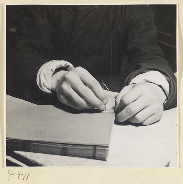 Man sewing the binding of a book