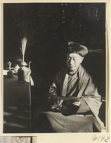 Monk reading next to an altar