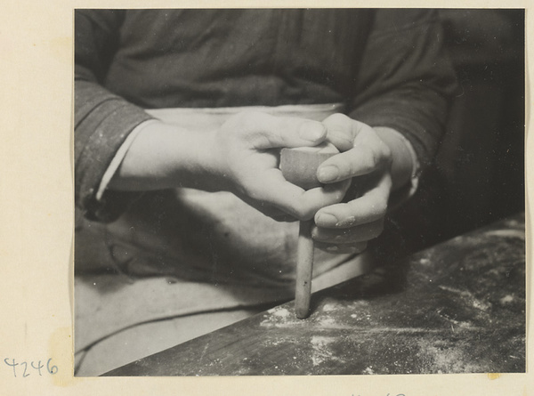 Man shaping a moon cake with a mold in a bakery