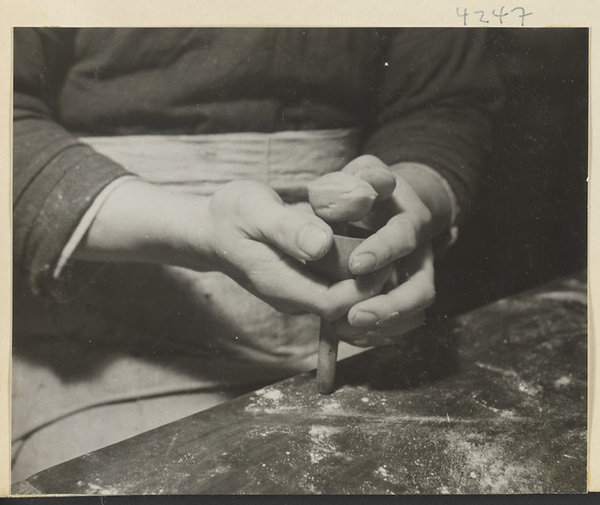 Man taking a moon cake out of a mold in a bakery