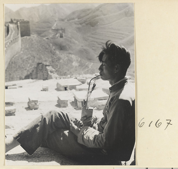 Man smoking a tobacco water pipe near the Great Wall