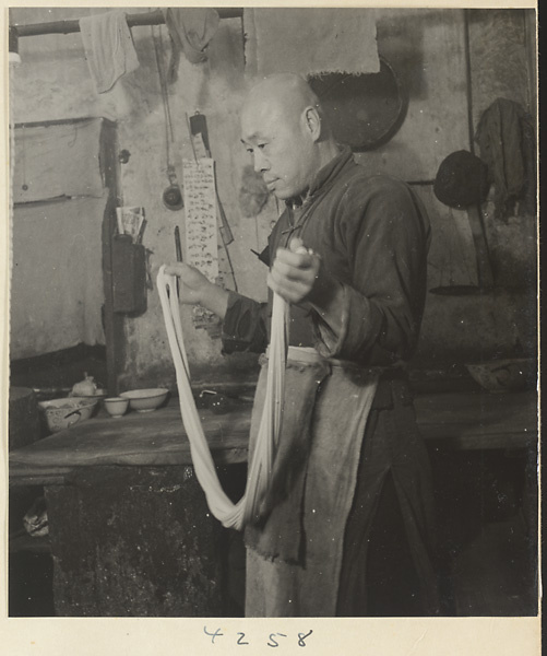 Restaurant interior showing a chef working with dough to make oil cakes