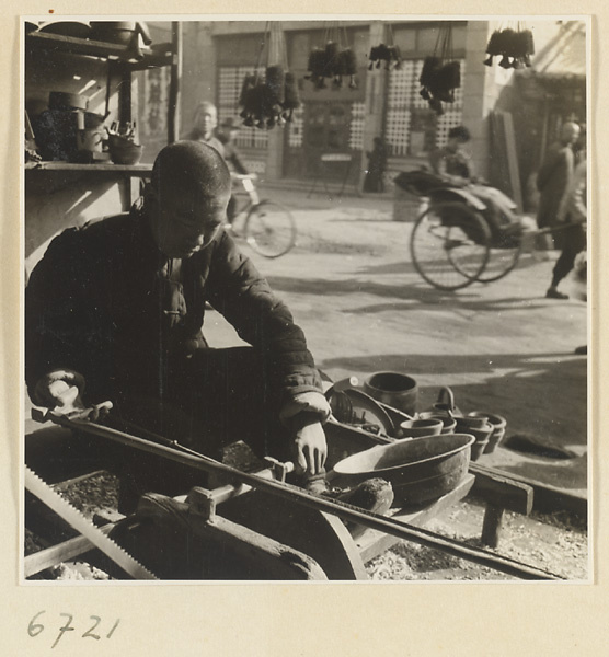 Carpenter turning a piece of wood at a lathe