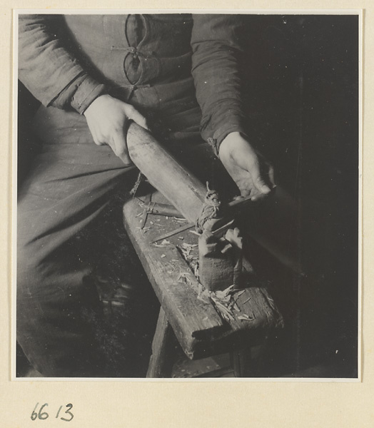 Man working on a piece of horn in a horn-comb workshop