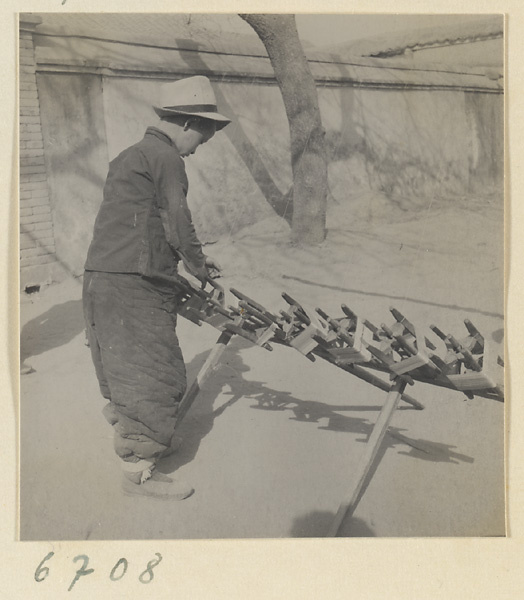 Boy spinning silk outdoors