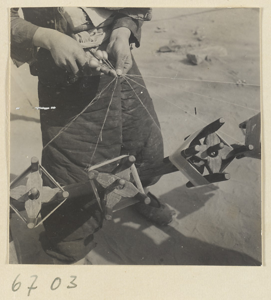 Boy spinning silk outdoors