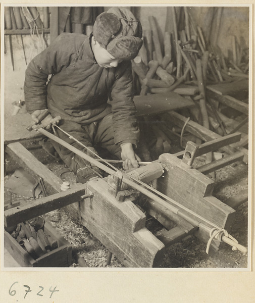 Carpenter turning a piece of wood at a lathe