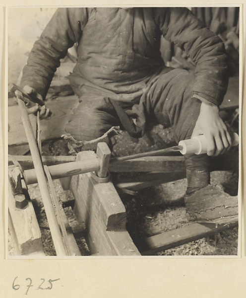 Carpenter turning a piece of wood at a lathe