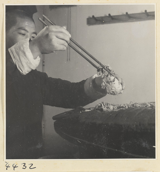 Kitchen of Niu Rou Wan, a Muslim grilled-beef restaurant, showing a chef removing food from a grill