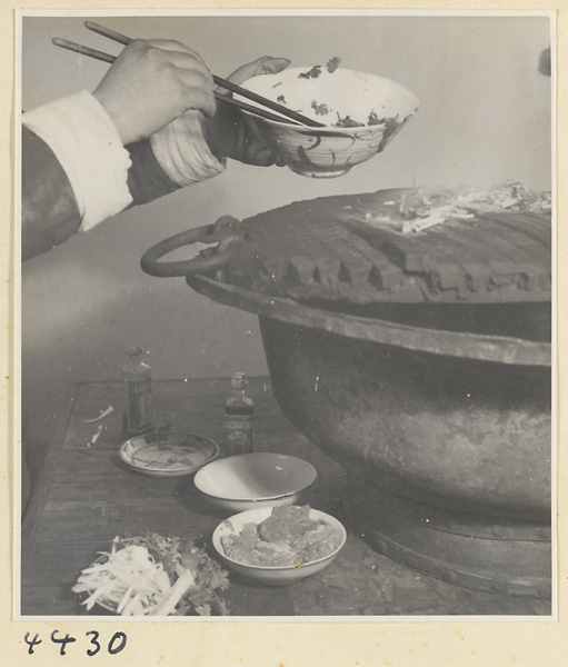 Kitchen of Niu Rou Wan, a Muslim grilled-beef restaurant, showing a chef putting food on a grill