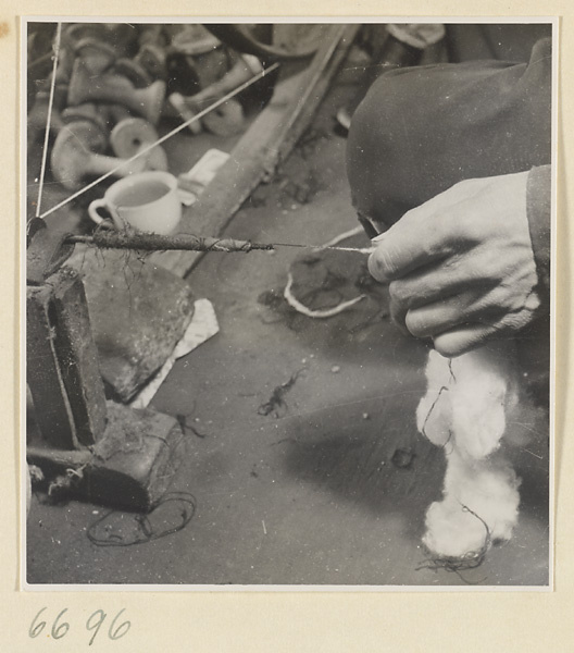 Man spinning cotton in a workshop