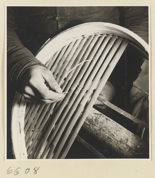 Man securing slats in a bamboo steamer in a workshop