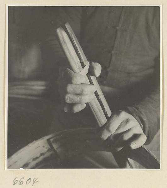 Man clamping the rim of a bamboo steamer in a workshop