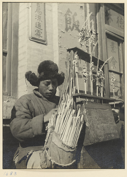 Street vendor at his stand selling toy figures made from colored rice flour