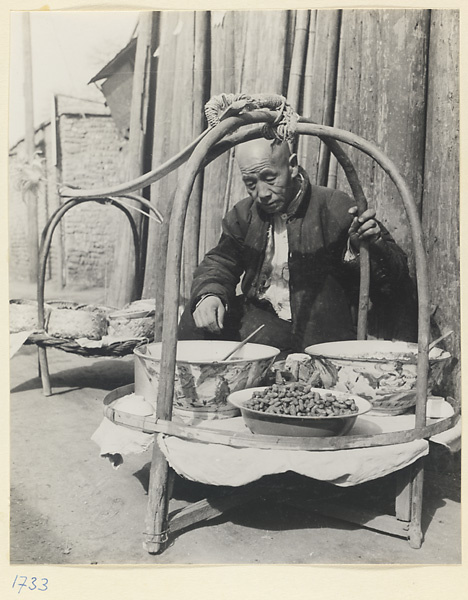 Street vendor selling food from stands attached to a shoulder pole