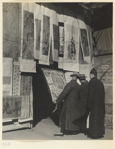 Men looking at scroll paintings for sale at New Year's market at Liuli Chang