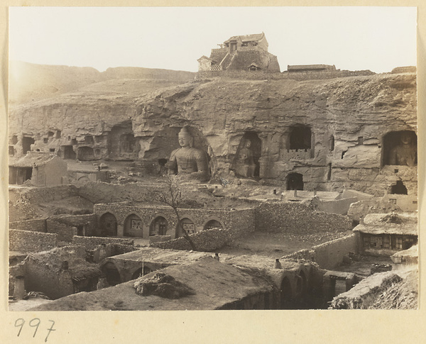 General view of Wuzhou Cliff face showing cave entrances and giant Buddha in Cave 20