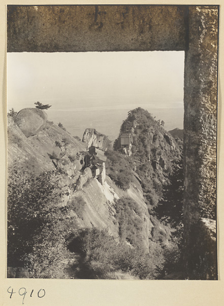 North Peak Ridge with Daoist monastery buildings on Hua Mountain seen through inscribed stone archway with Yellow River in background