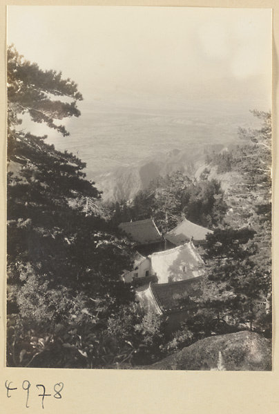 Rooftops of Daoist monastery buildings on East Peak of Hua Mountain with plains in background