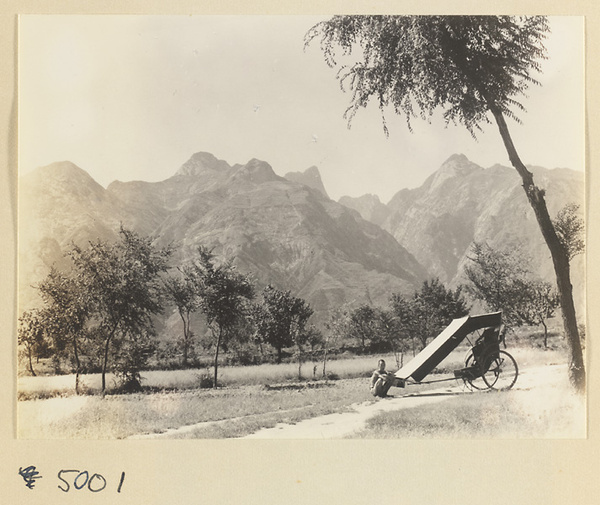 Rickshaw puller in valley with Hua Mountain in background