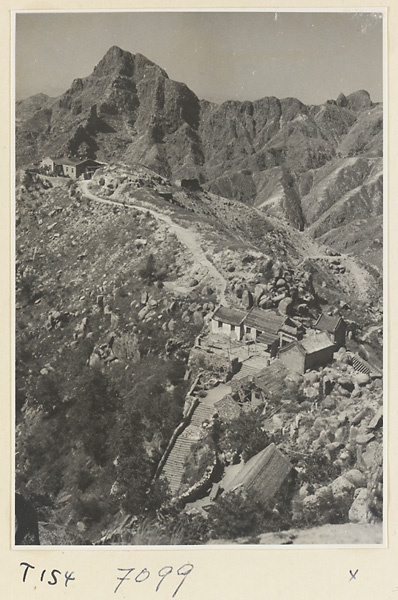 Trail up Tai Mountain with stone steps, buildings, and view of Ao Mountain in the background