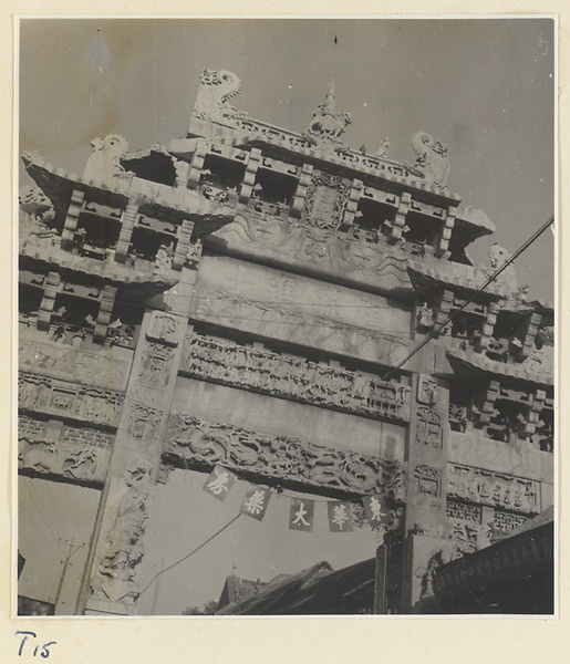 Detail of pai lou in Qufu showing relief work, sign board, inscription, and inscribed banner hung from the central arch