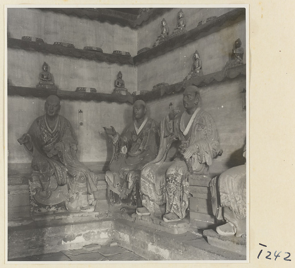 Interior of a temple building at Ling yan si showing statues of Luohans and figurines of Buddhas