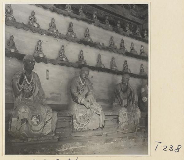 Interior of a temple building at Ling yan si showing statues of Luohans and figurines of Buddhas