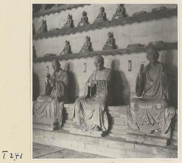 Interior of a temple building at Ling yan si showing statues of Luohans and figurines of Buddhas