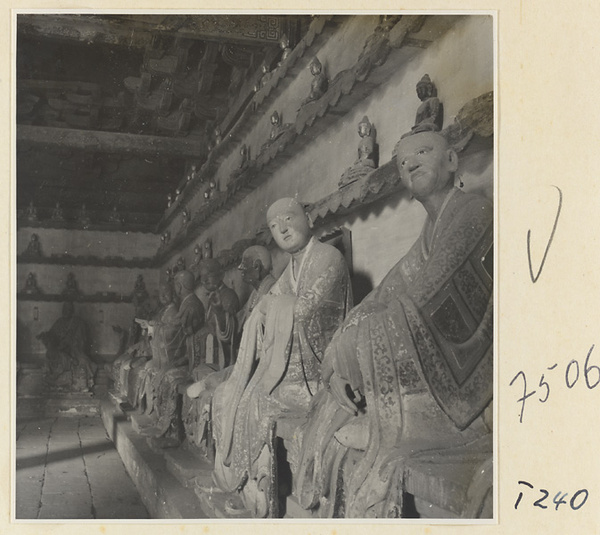 Interior of a temple building at Ling yan si showing statues of Luohans and figurines of Buddhas