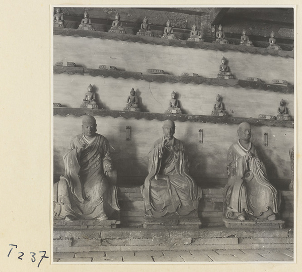 Interior of a temple building at Ling yan si showing statues of Luohans and figurines of Buddhas