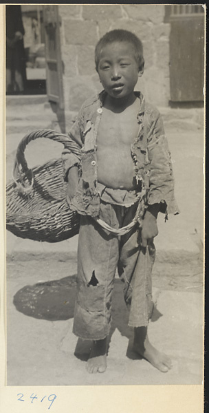 Boy holding a basket in a fishing village on the Shandong coast