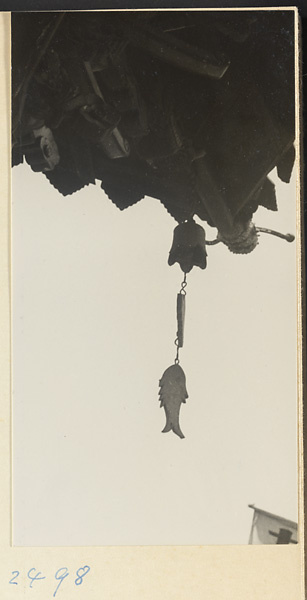 Bell and fish-shaped ornament hanging from a roof in a village on the Shandong coast