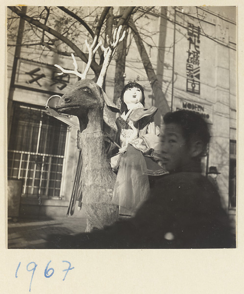 Paper figure of a woman mounted on a deer in a funeral procession