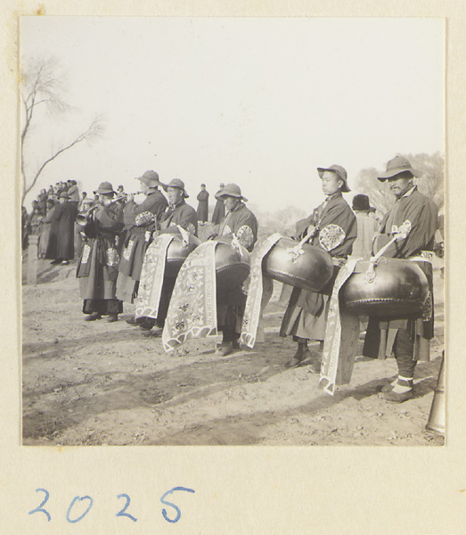 Musicians playing drums and suo na beside the grave at a funeral