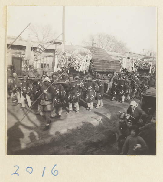 Coffin-bearers carrying draped coffin in funeral procession