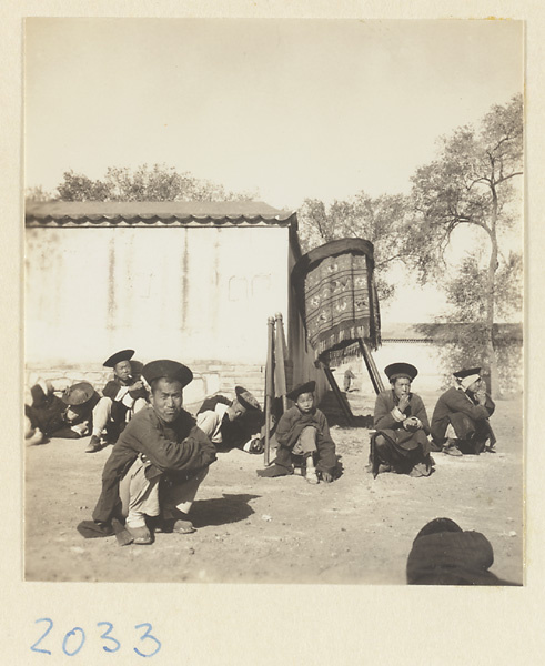 Men with embroidered umbrella waiting to join wedding procession