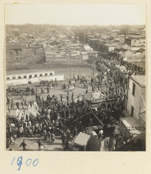 Members of a funeral procession with draped coffin crossing a bridge over a city moat